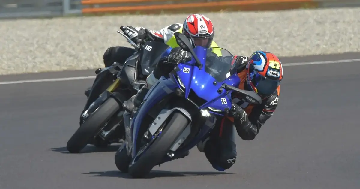 A motorcycle instructor shows the ideal line during guided race track training for beginners in Italy.