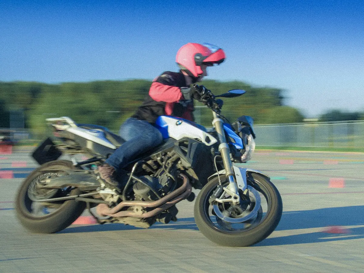 A rider practices cornering technique and lean angle on a BMW during a riding safety training.
