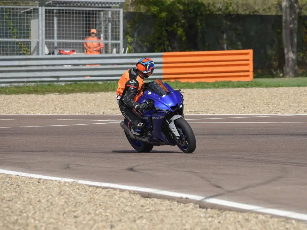 Ein Instruktor auf einer Yamaha R1 dreht sich während der Fahrt nach hinten um, um die Position der Teilnehmer beim Gruppentraining in Modena zu überprüfen.