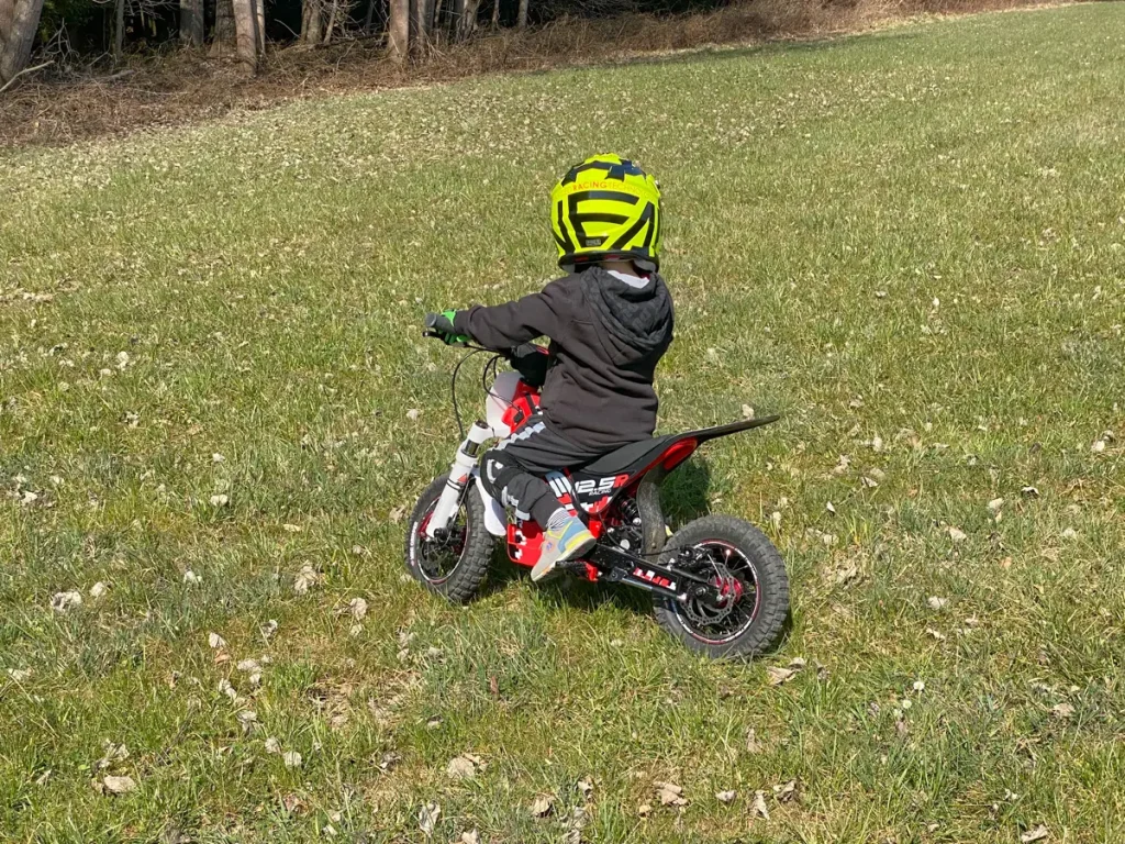 Spielerischer Einstieg: Ein Kind übt sicher und mit viel Spaß auf einem leisen Elektro-Bike im Gras.
