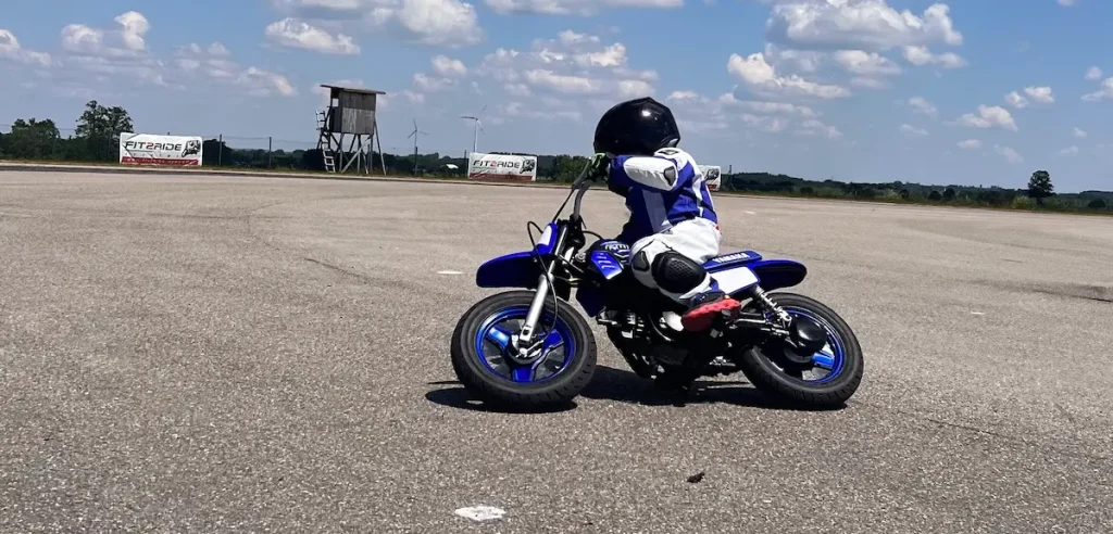 Selbstständig unterwegs: Ein Kind trainiert in voller Schutzausrüstung konzentriert das Kurvenfahren auf einer Yamaha PW50.