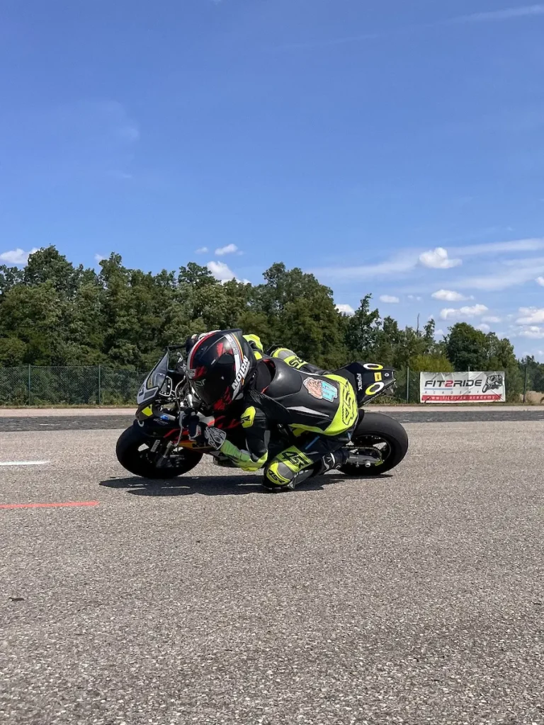 Nachwuchstalent in perfekter Hang-Off-Position mit Knie am Boden beim Jugendtraining.