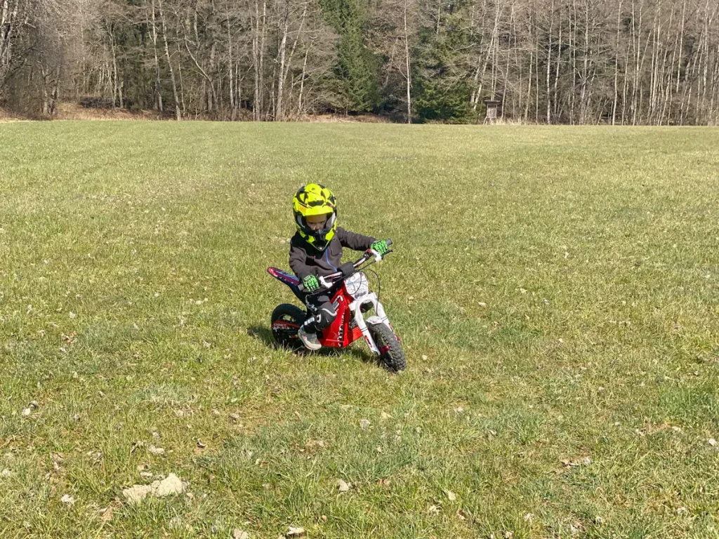 Spielerischer Erstkontakt: Ein Kind probiert das Motorradfahren auf einem leisen, einsteigerfreundlichen OSET Elektro-Bike aus.