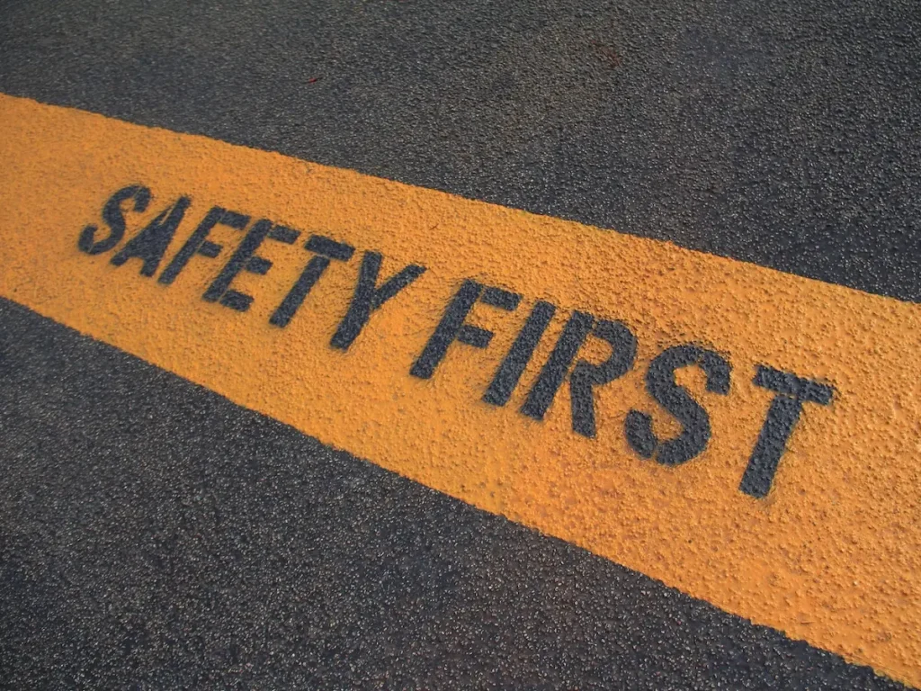 Gelbe Bodenmarkierung mit der Aufschrift SAFETY FIRST auf dem Übungsplatz für Motorradtraining.
