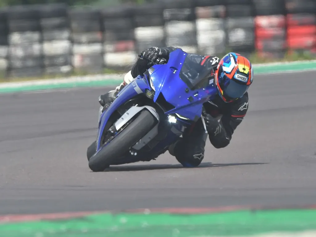 Dynamische Frontansicht einer Yamaha R1 in tiefer Schräglage beim freien Fahren auf der Rennstrecke.